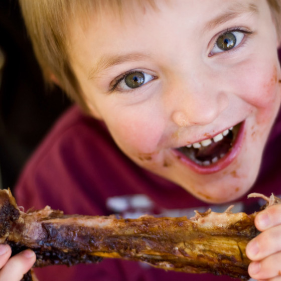boy eating ribs at Houston Rodeo BBQ Cook-Off